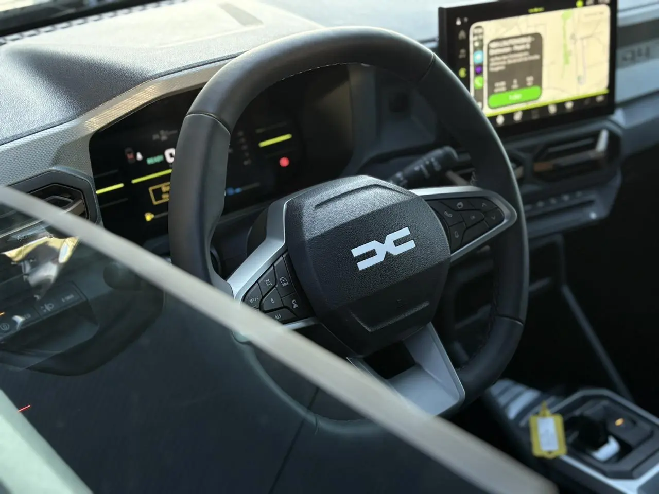 Vue rapprochée du volant et tableau de bord digital du Dacia Duster 2025, intérieur moderne avec écran tactile GPS.