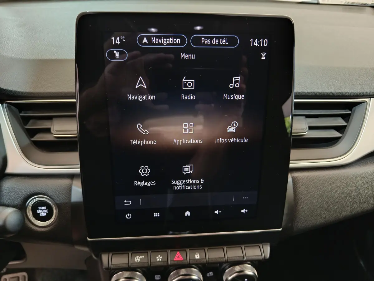 Écran tactile central allumé du tableau de bord du Renault Captur Techno TCe 90 gris foncé, avec bouton démarrage visible.