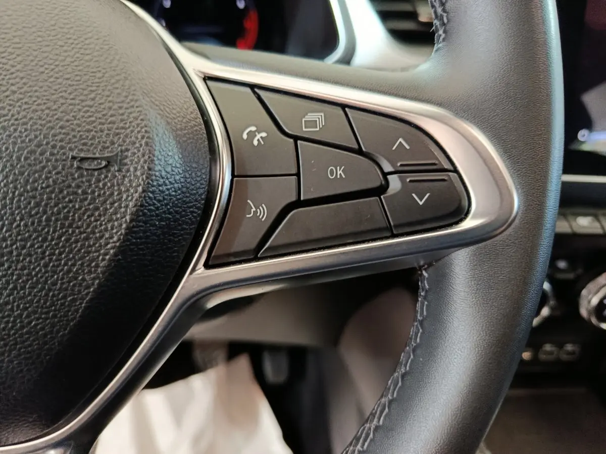 Gros plan sur les commandes du volant en cuir noir du Renault Captur techno TCe 90 2024, boutons multifonctions visibles.