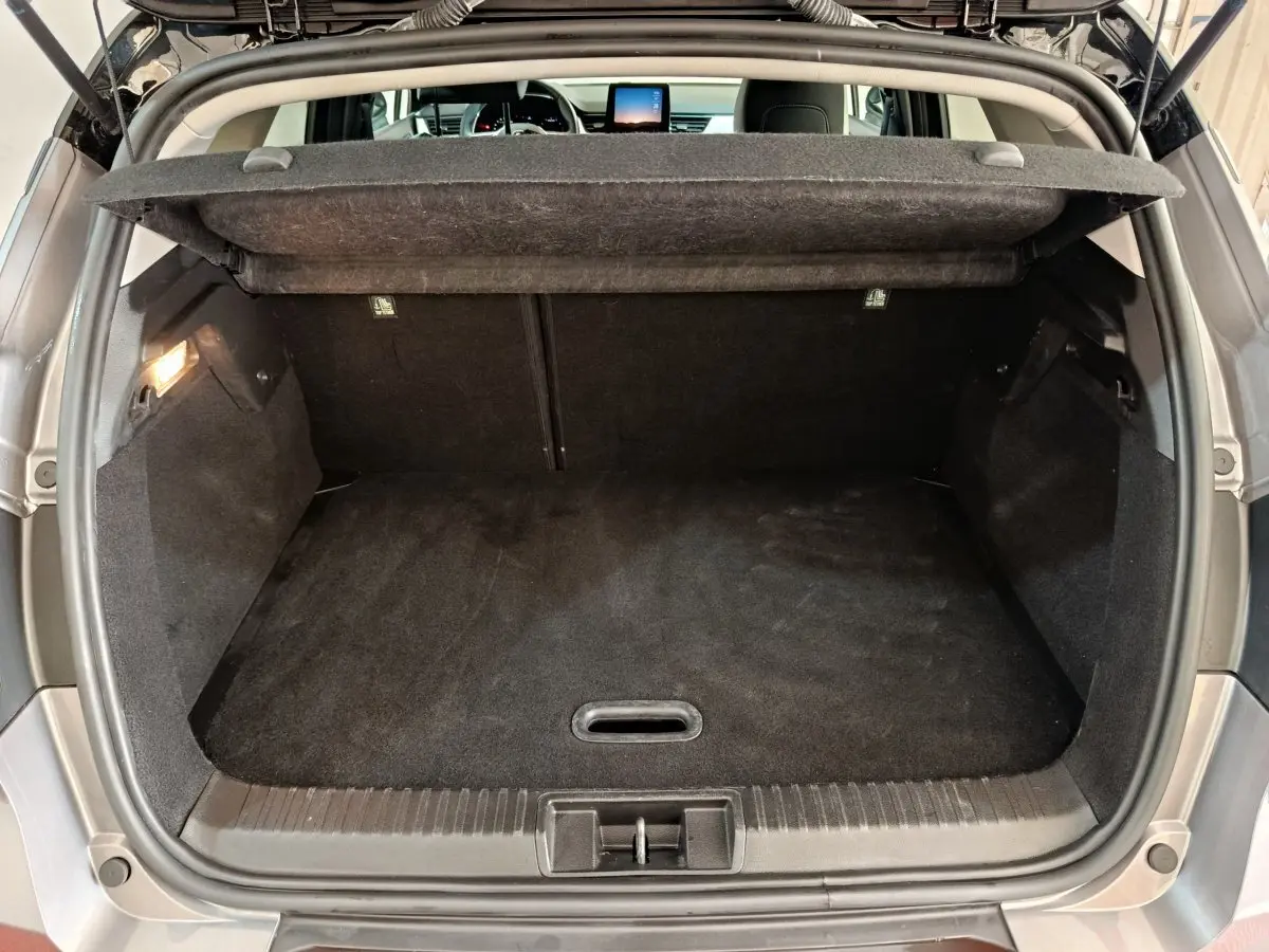 Coffre ouvert du Renault Captur Techno TCe 90 gris foncé, vue arrière avec tablette cache-bagages relevée.