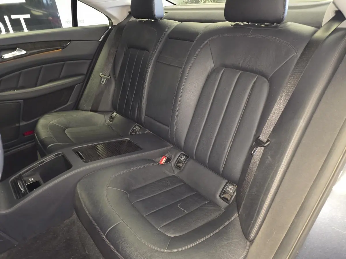 Vue intérieure sur les sièges arrière en cuir noir de la Mercedes Classe CLS 250 CDI FAP gris, avec accoudoir central.