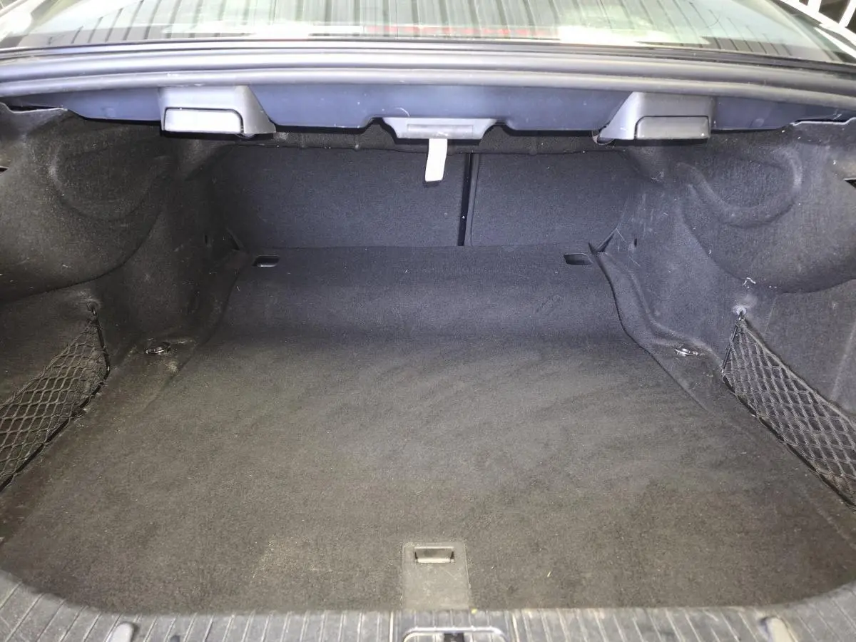 Coffre vide de Mercedes Classe CLS 250 CDI gris, vue intérieure arrière avec filet de rangement latéral.