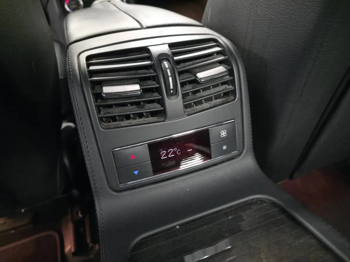 Vue rapprochée de la console centrale arrière avec commandes de climatisation affichant 22°C dans une Mercedes CLS gris.
