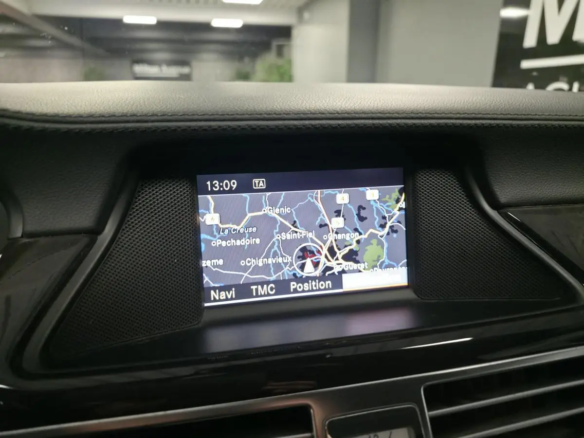 Écran de navigation central allumé dans l'habitacle cuir noir d'une Mercedes CLS 250 CDI FAP 2011.