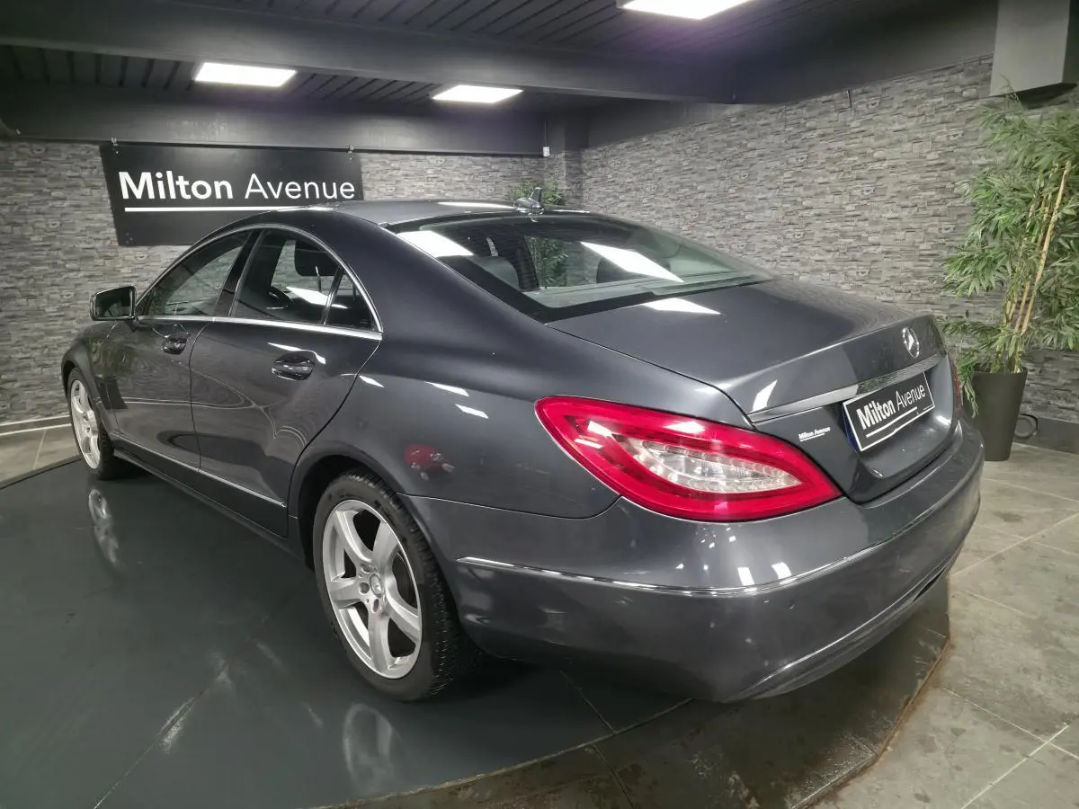 Mercedes Classe CLS gris métallisé vue 3/4 arrière droit avec jantes alliage 5 branches en intérieur showroom