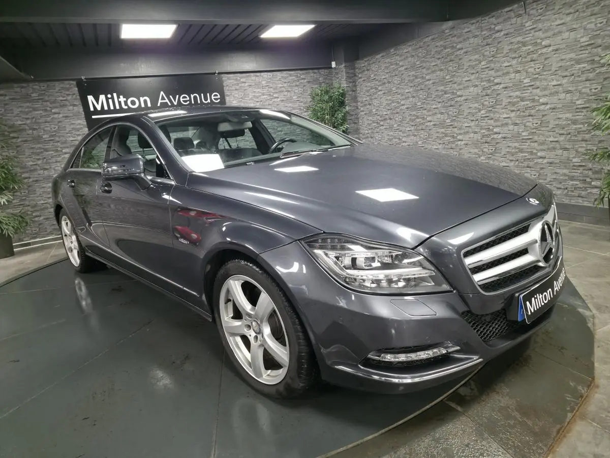 Mercedes Classe CLS gris métallisé vue 3/4 avant droit avec jantes alliage 5 branches en intérieur showroom.