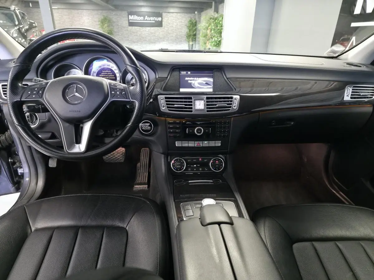 Intérieur noir cuir de la Mercedes CLS 250 CDI 2011, vue frontale sur le tableau de bord et volant multifonctions.