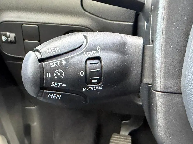 Gros plan sur la commande de régulateur de vitesse du Citroën C3 2023, finition Shine, intérieur noir.