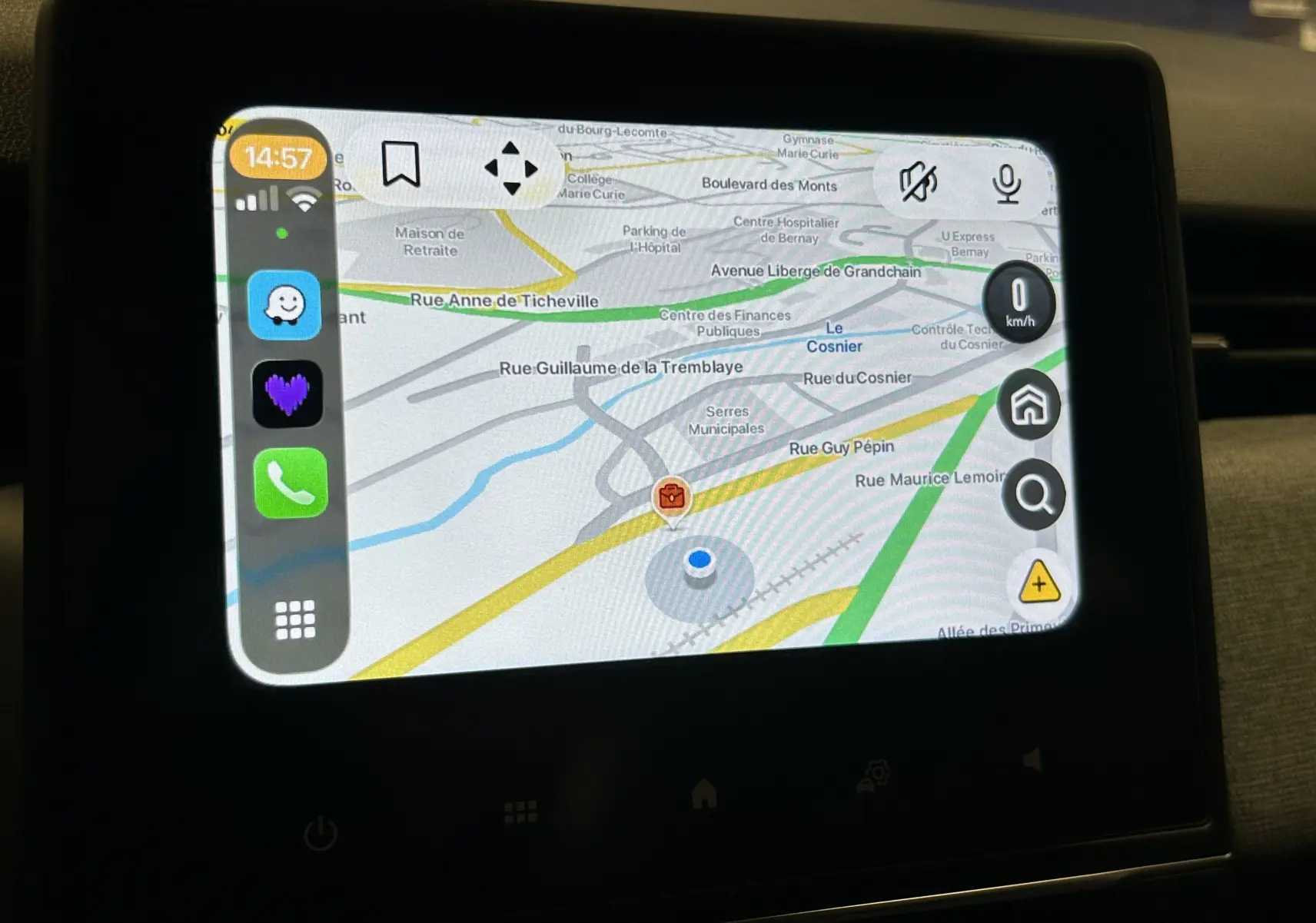 Écran tactile du système GPS de la Renault Clio V blanche, affichant une carte routière avec options de navigation.