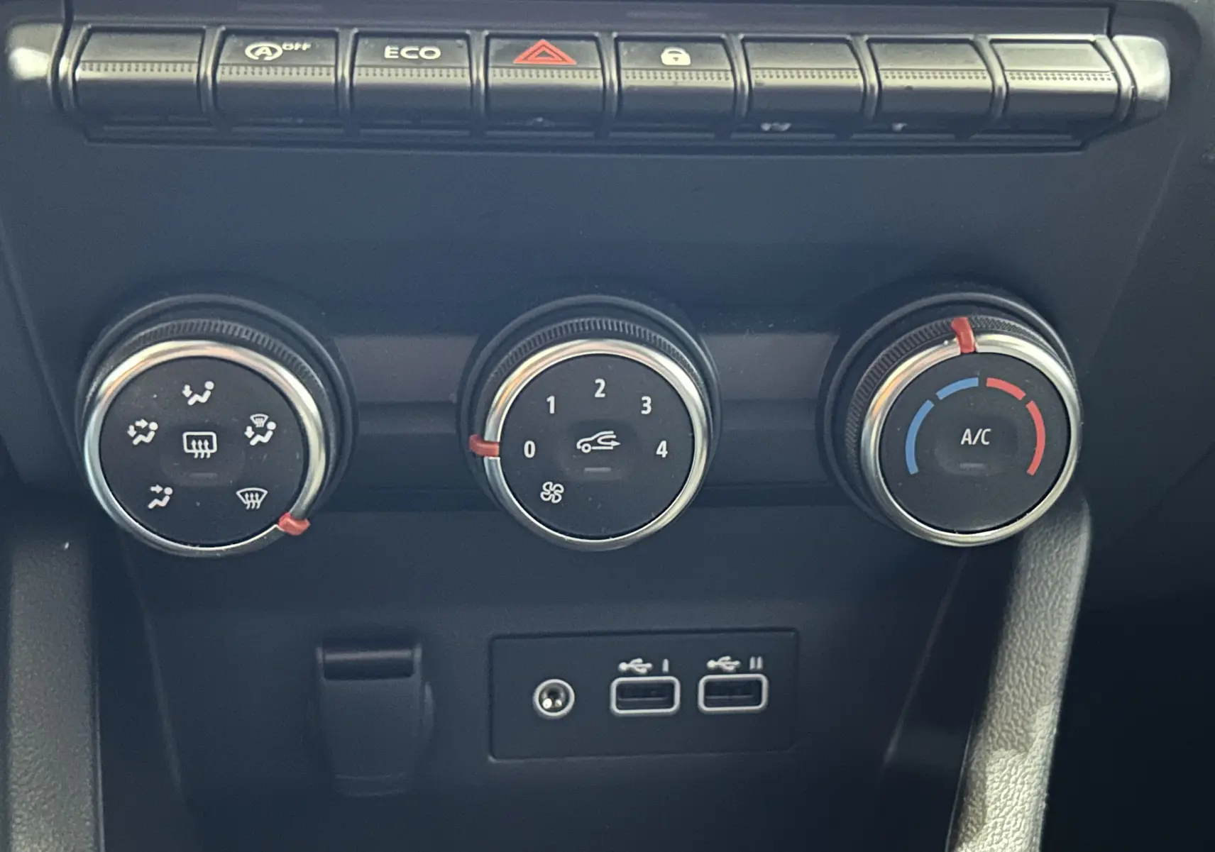 Détail de la console centrale de la Renault Clio V blanche, montrant les commandes de climatisation et deux ports USB.