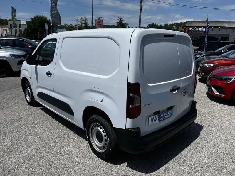Vue 3/4 arrière droite d’un Opel Combo Cargo blanc 2024, fourgon utilitaire avec porte arrière pleine et jantes acier.