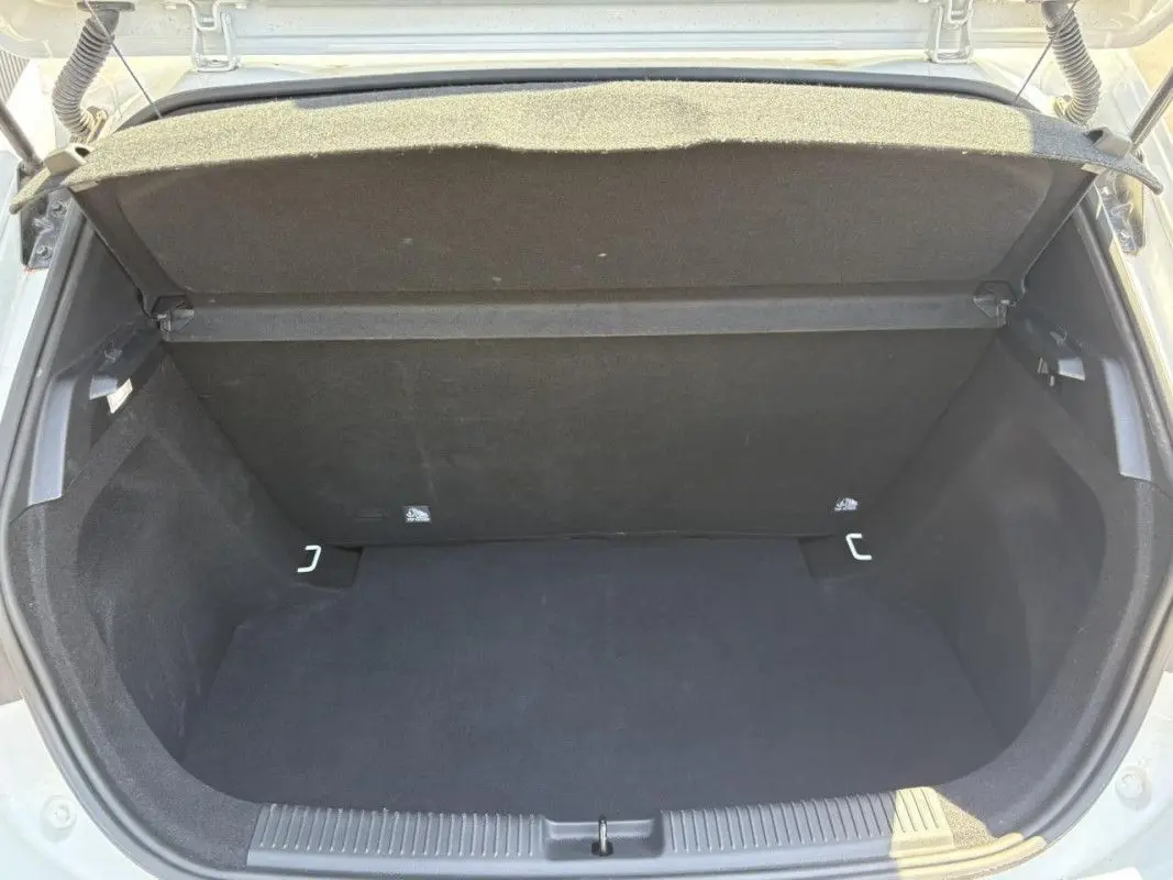 Coffre ouvert vu de l'arrière d'une MG3 1.5 HYBRID+ 195 COMFORT blanche, montrant un espace de rangement vide et propre.