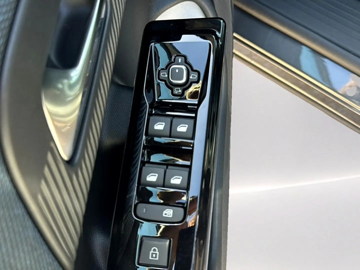 Gros plan sur la commande des vitres électriques côté gauche d'une Citroën C5 Aircross gris platinium avec insert noir brillant.