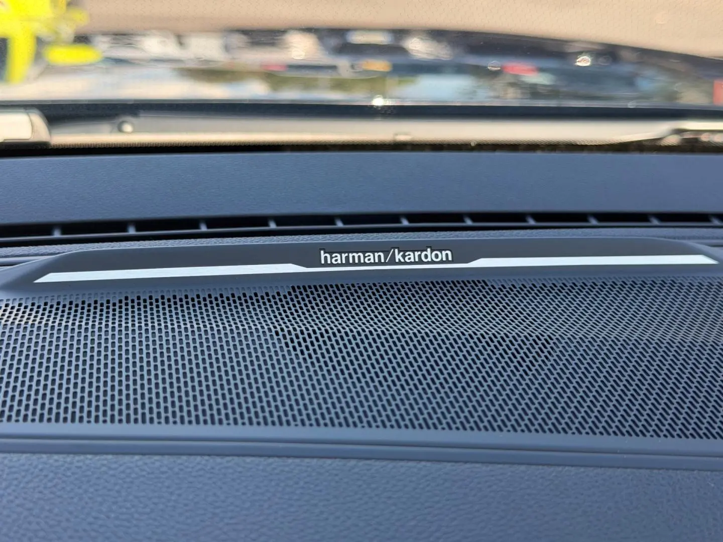 Gros plan sur la grille haut-parleur Harman Kardon intégrée au tableau de bord du Renault Austral noir étoilé.