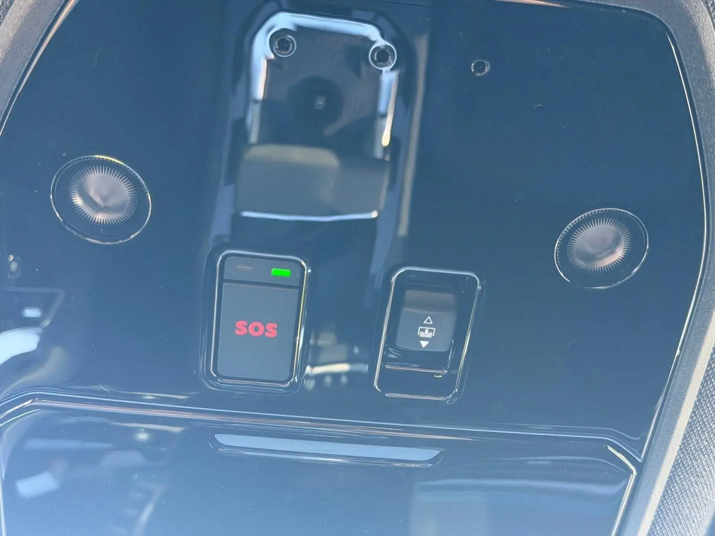 Gros plan sur la console de toit noire brillante du Renault Austral 2026 avec bouton SOS rouge et commande de toit ouvrant.