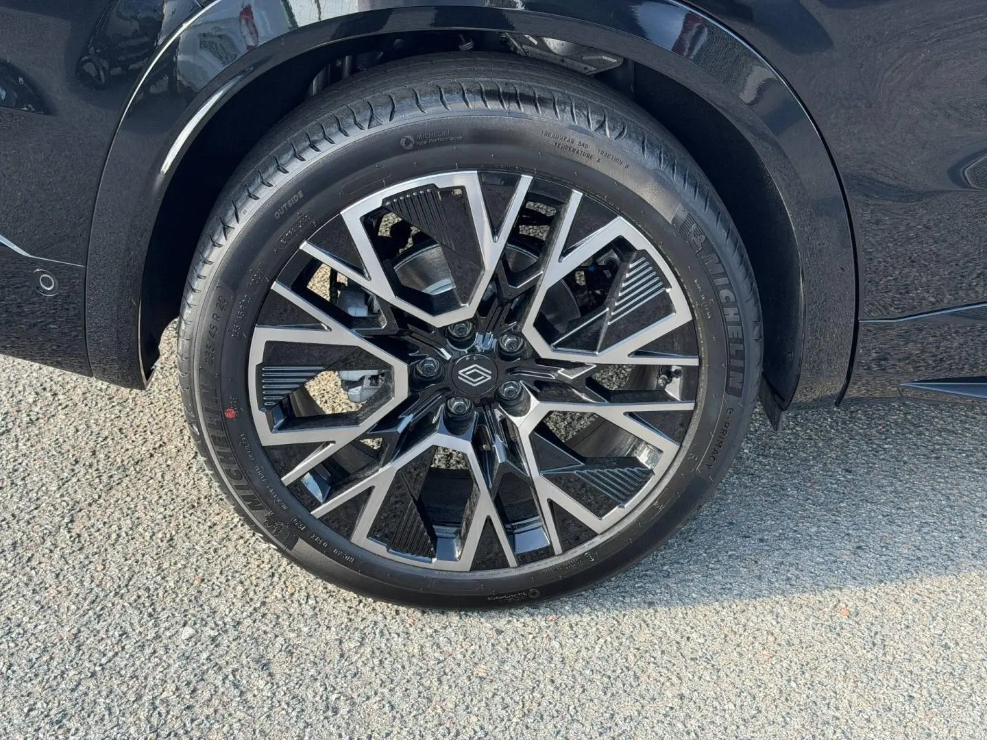 Gros plan sur la jante alu noire et argentée du côté arrière droit du Renault Austral noir étoilé métallisé.