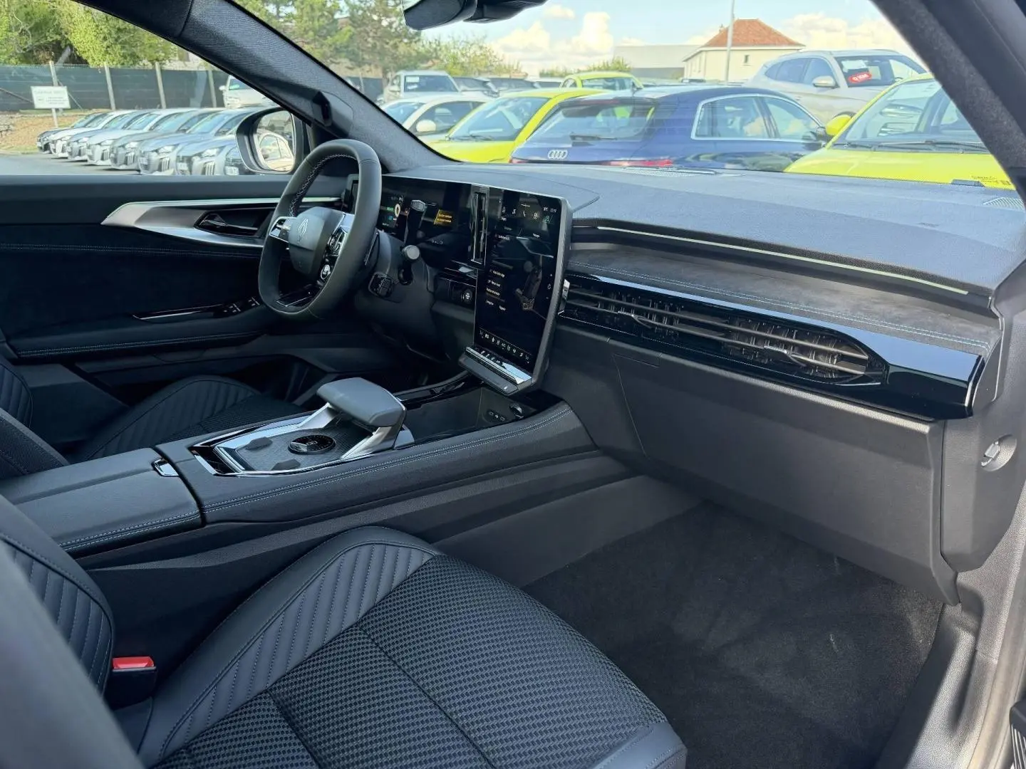 Intérieur avant droit du Renault Austral 2026 noir étoilé, avec écran tactile vertical et sièges en tissu carbone Alcantara.