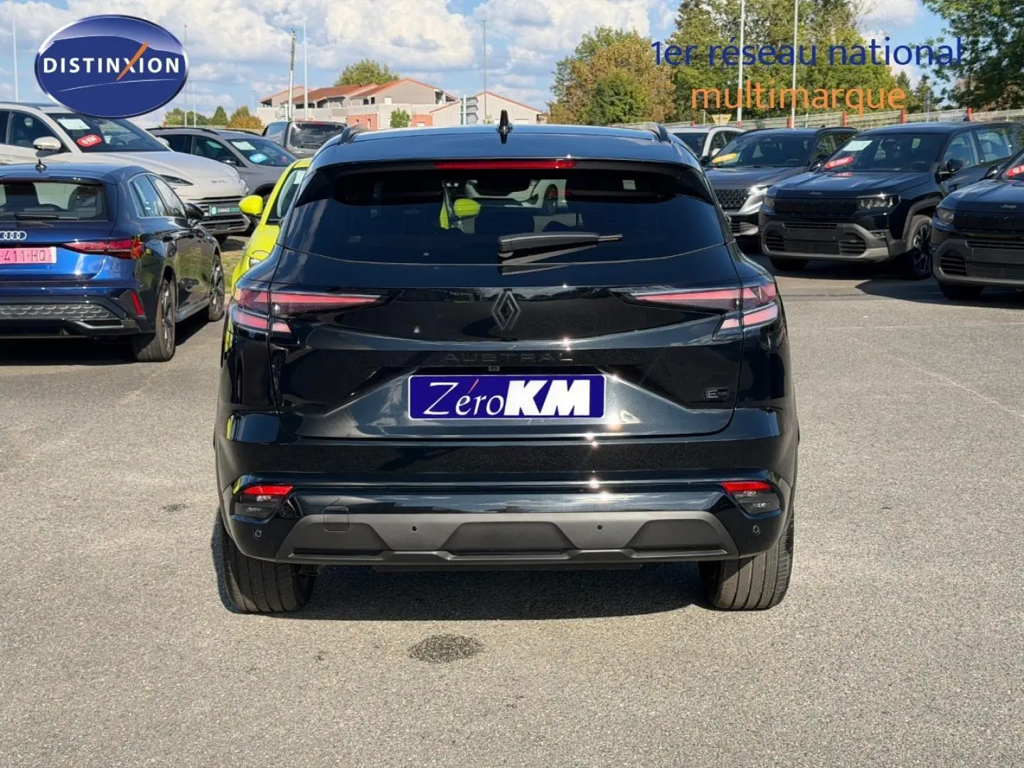 Vue arrière d'un Renault Austral noir étoilé métallisé garé sur un parking extérieur avec plusieurs véhicules autour.