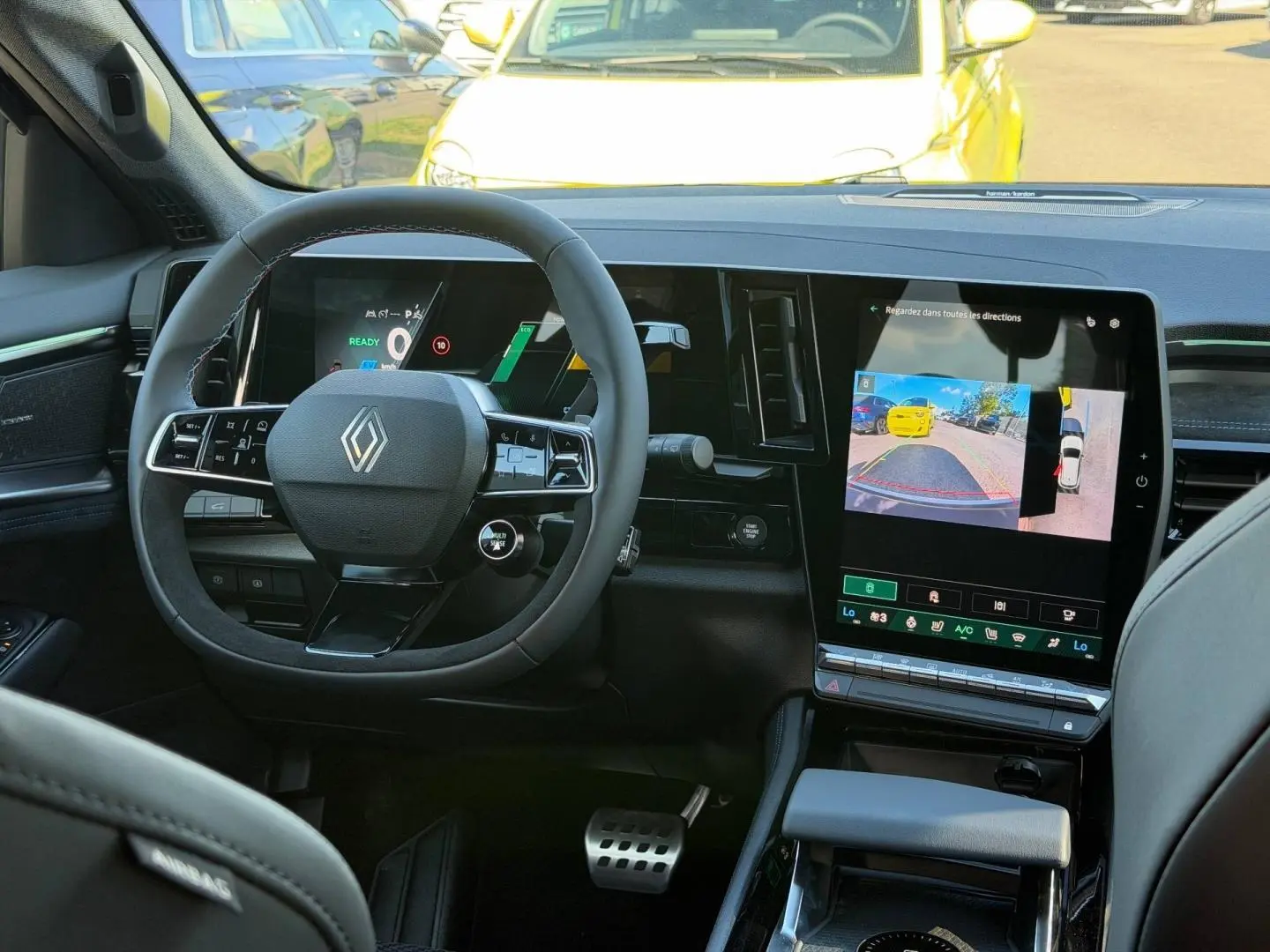 Vue intérieure frontale du tableau de bord noir du Renault Austral 2026 avec écran tactile et volant multifonction.