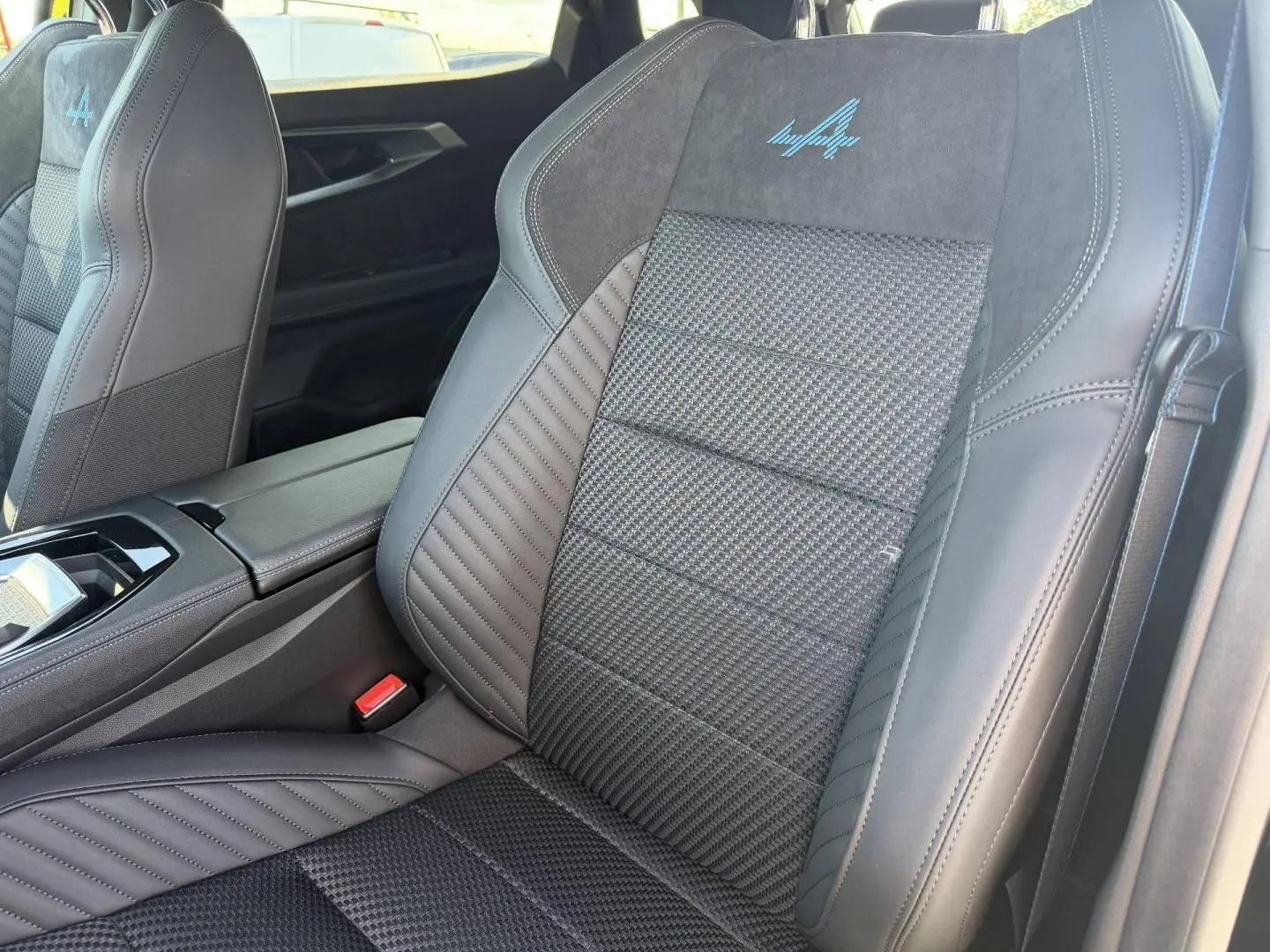 Gros plan sur les sièges avant noirs avec logo Alpine bleu, intérieur cuir et Alcantara du Renault Austral 2026.