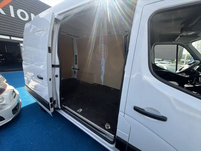 Vue latérale droite du Renault Master blanc 2021 avec porte coulissante ouverte montrant l'espace de chargement vide.