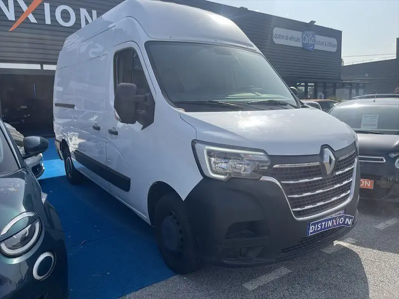 Renault Master blanc en vue 3/4 avant droit, fourgon utilitaire avec calandre noire et phares LED visibles.