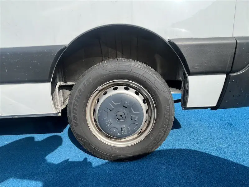 Gros plan sur la roue arrière droite blanche d'un Renault Master 2021 avec jante acier et enjoliveur gris.