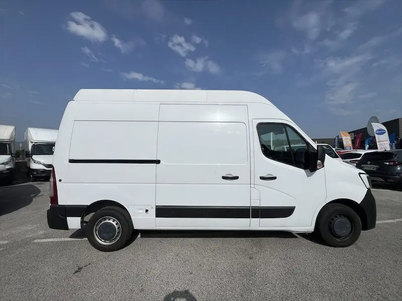 Vue de profil côté gauche d'un Renault Master blanc 2021 avec toit surélevé et bandes noires latérales.