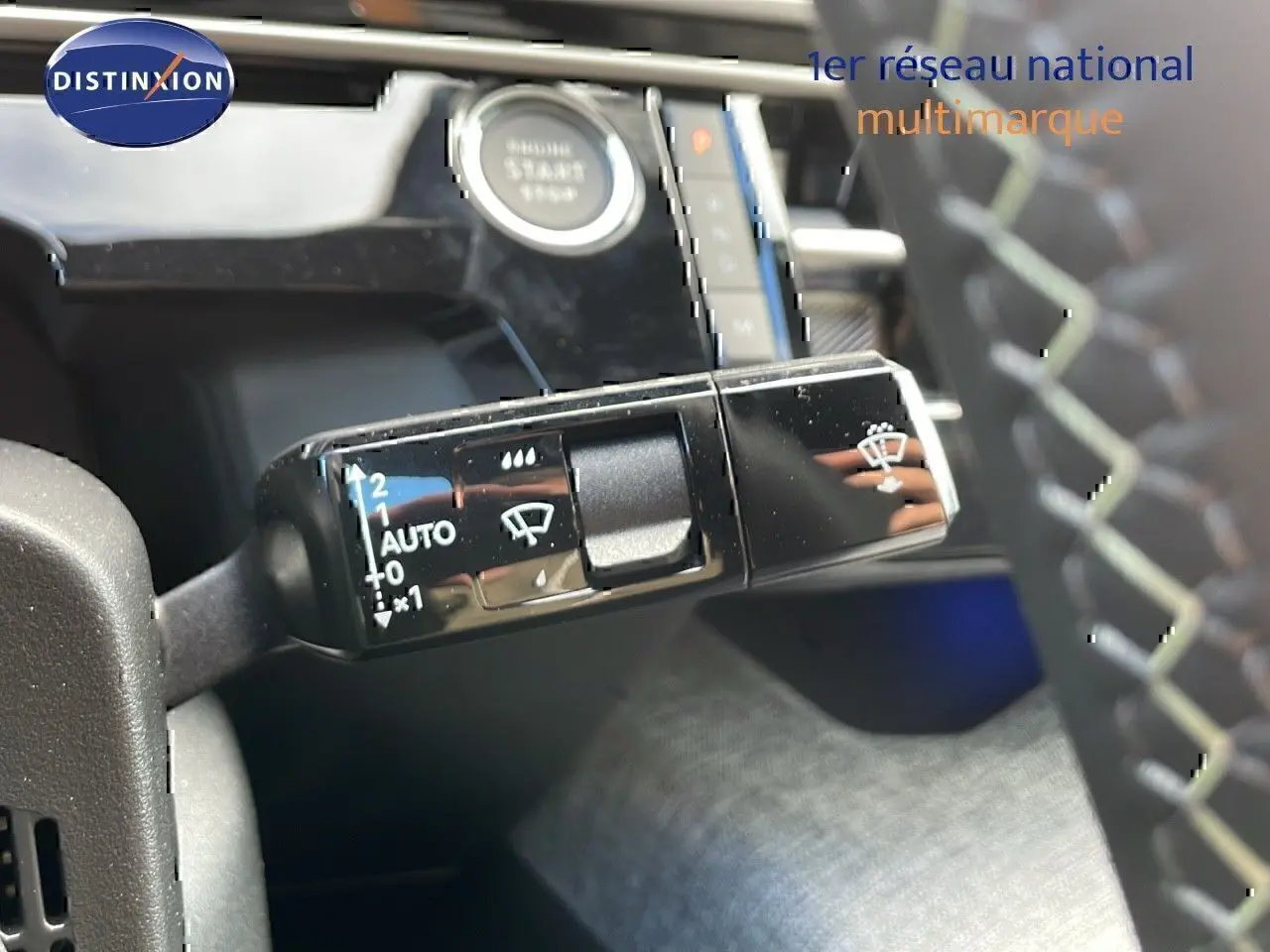Gros plan sur la commande d’essuie-glace à gauche du volant du Peugeot 3008 2025 bleu Ingaro métal avec toit noir.