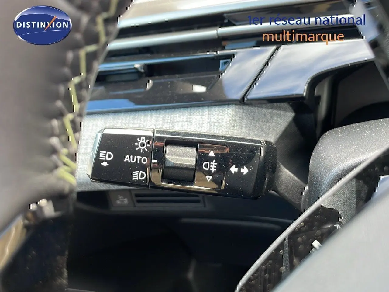 Gros plan sur la commande des feux et clignotants à gauche du volant dans l’habitacle du Peugeot 3008 bleu Ingaro 2025.
