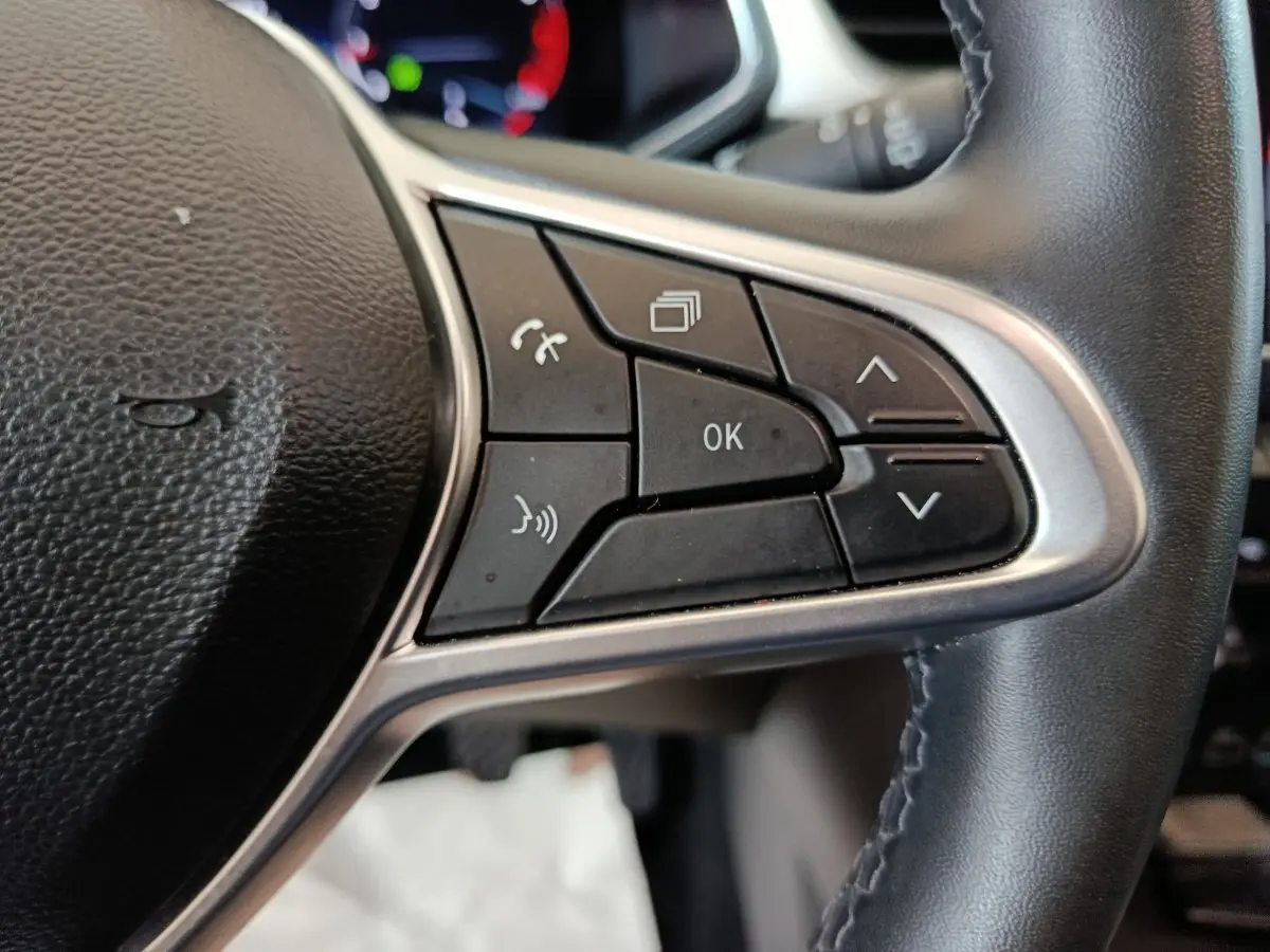 Gros plan sur les commandes multifonctions côté droit du volant noir du Renault Captur rouge Techno TCe 90 2024