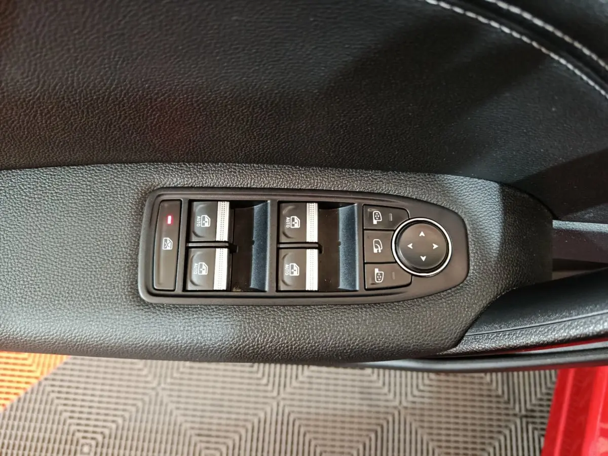 Commande des vitres et rétroviseurs sur la portière côté gauche d'un Renault Captur rouge 2024 finition techno TCe 90.