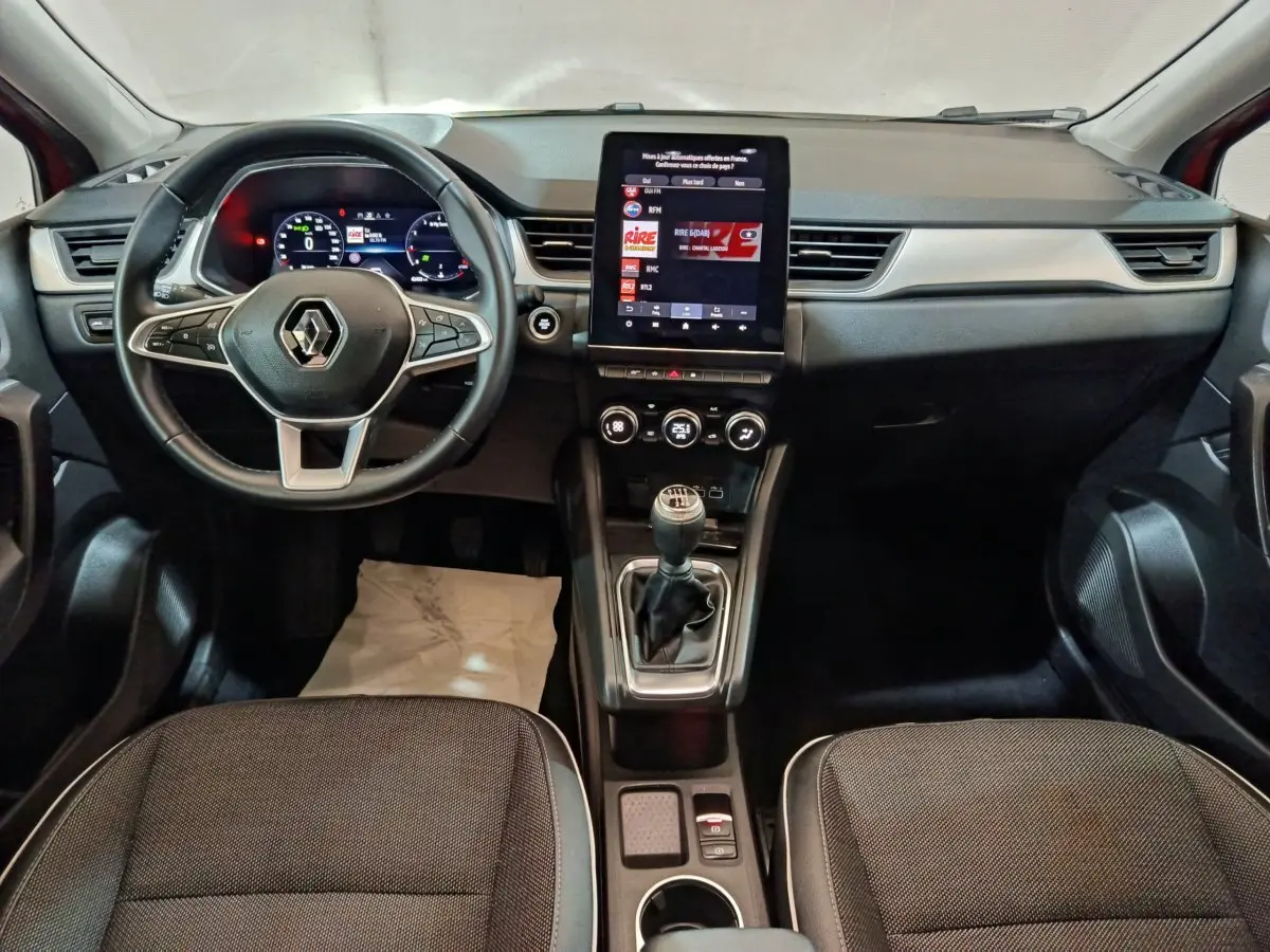 Intérieur Renault Captur 2024 vue avant, tableau de bord noir avec écran tactile vertical et boîte manuelle.