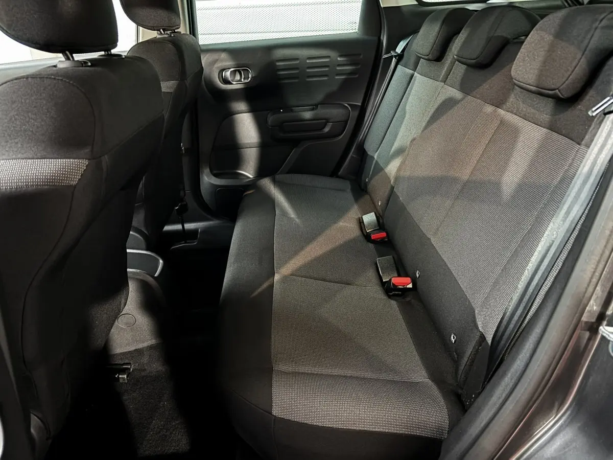 Banquette arrière en tissu gris vue côté droit dans le Citroën C3 Aircross 2024, avec ceintures de sécurité visibles.