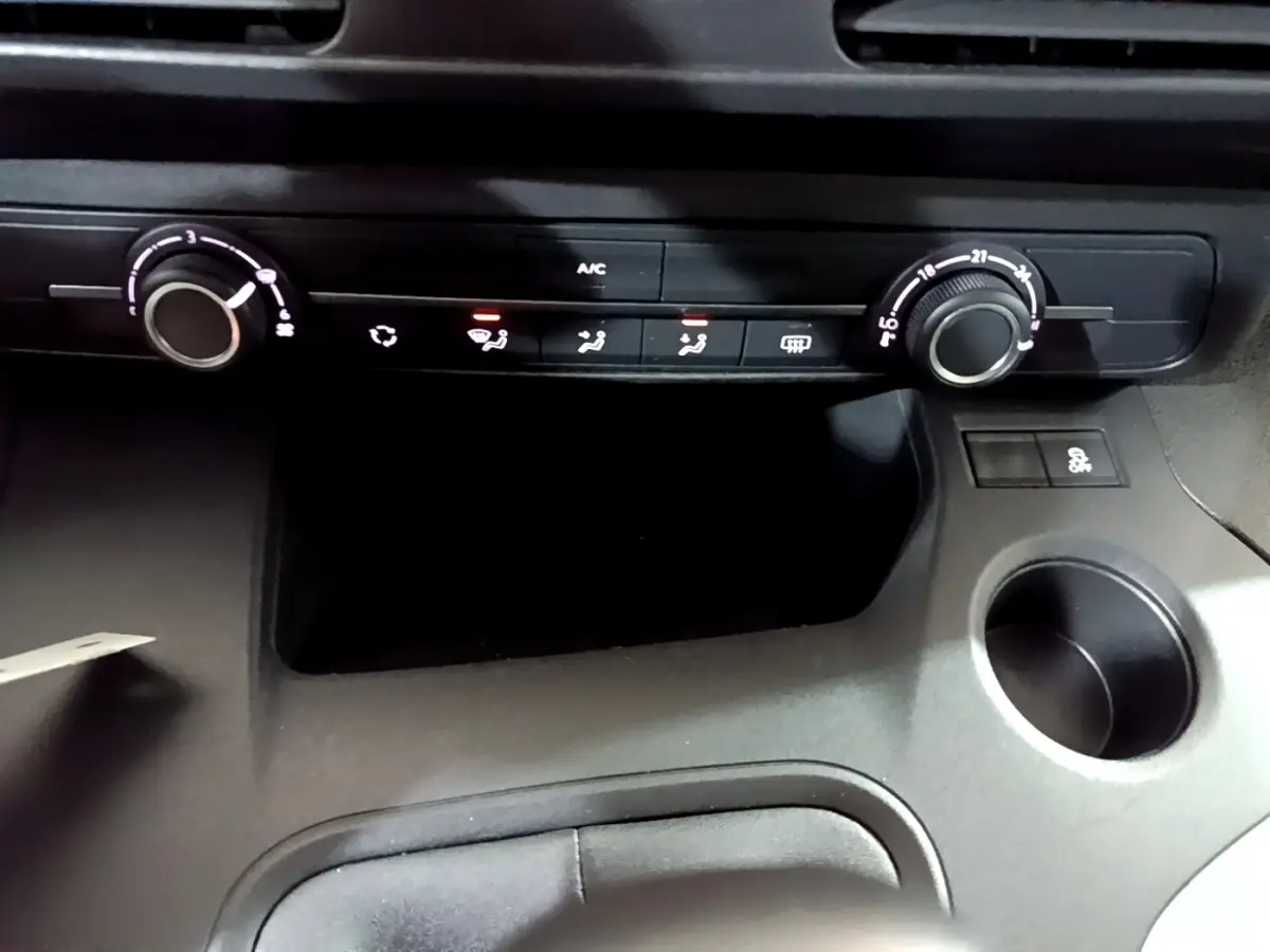 Détail de la console centrale du Citroën Berlingo XL blanc 2019, montrant les commandes de climatisation et un porte-gobelet.