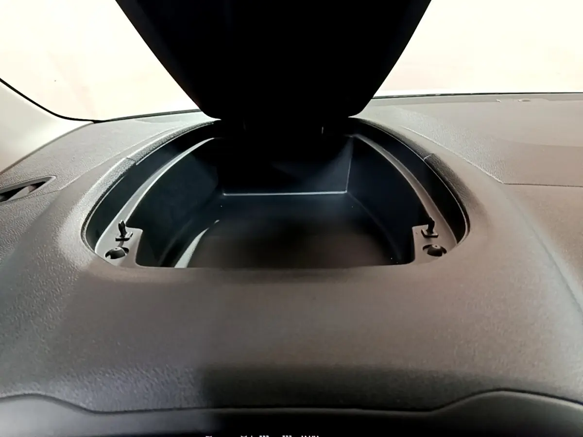 Vue rapprochée du rangement ouvert sur le tableau de bord noir d’un Citroën Berlingo XL blanc, version 2019.