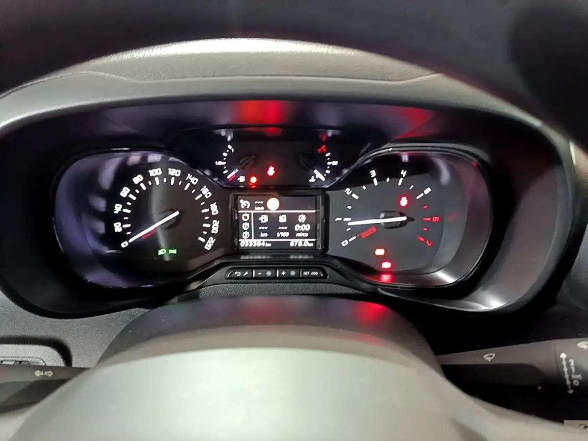 Vue rapprochée du tableau de bord du Citroën Berlingo blanc 2019, affichage numérique et compteurs analogiques.