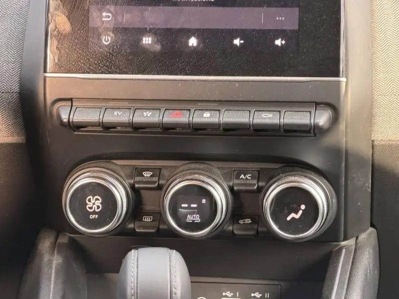 Détail de la console centrale avec commandes de climatisation et boutons multifonctions dans une Renault Clio Gris Rafale 2025.