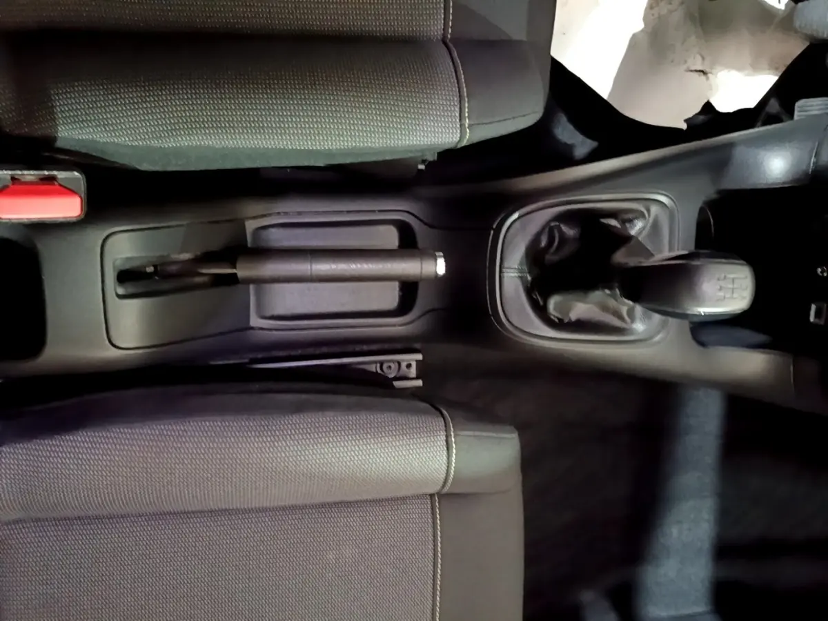 Vue plongeante sur la console centrale de la Citroën C3 bleu, montrant levier de vitesse manuel et frein à main.