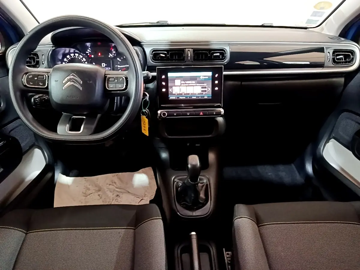 Vue intérieure avant de la Citroën C3 2017, tableau de bord noir avec écran tactile central et volant multifonctions.