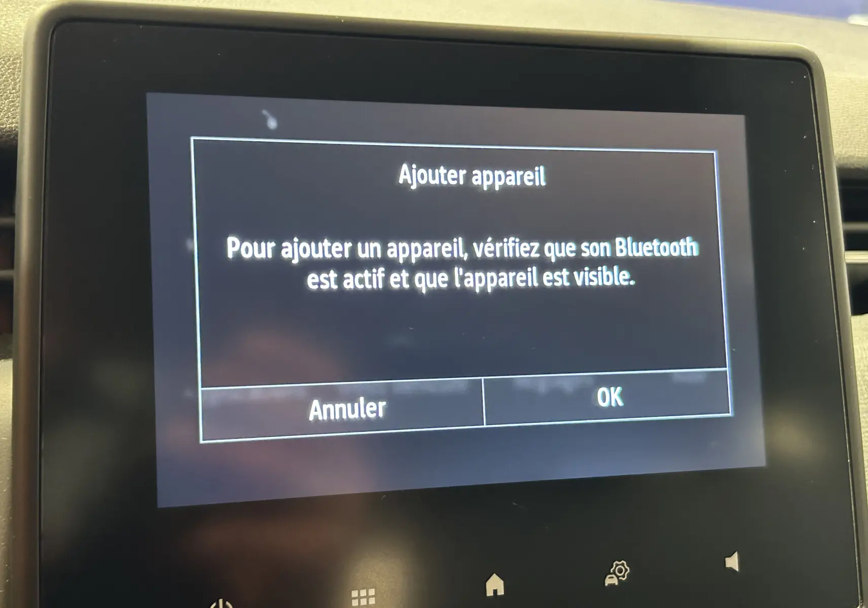 Écran tactile intérieur de Renault Clio V noir affichant un message d'ajout d'appareil Bluetooth.