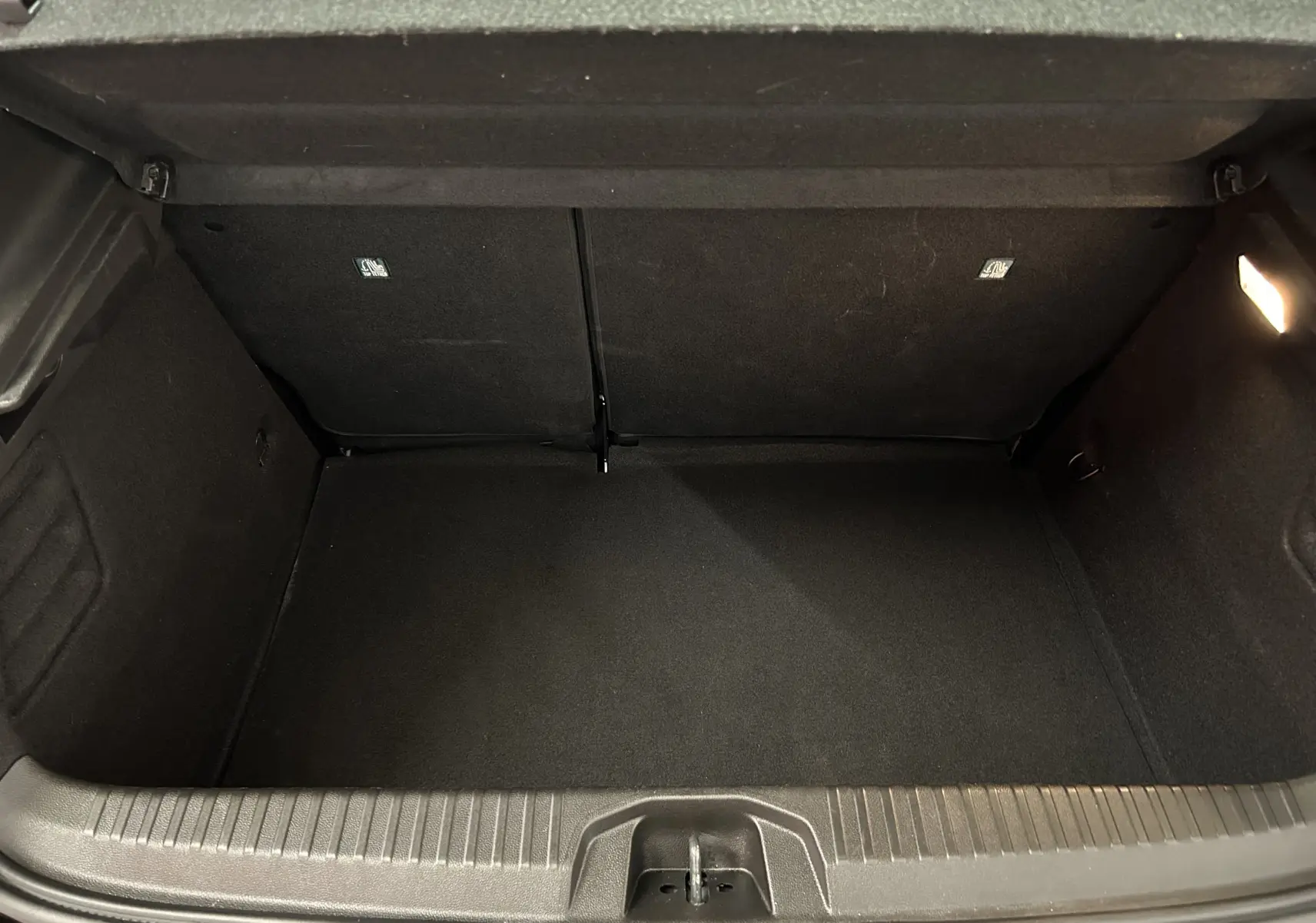 Coffre ouvert vu de face, intérieur noir propre et spacieux de la Renault Clio V BluedCi 100 Evolution 2025.