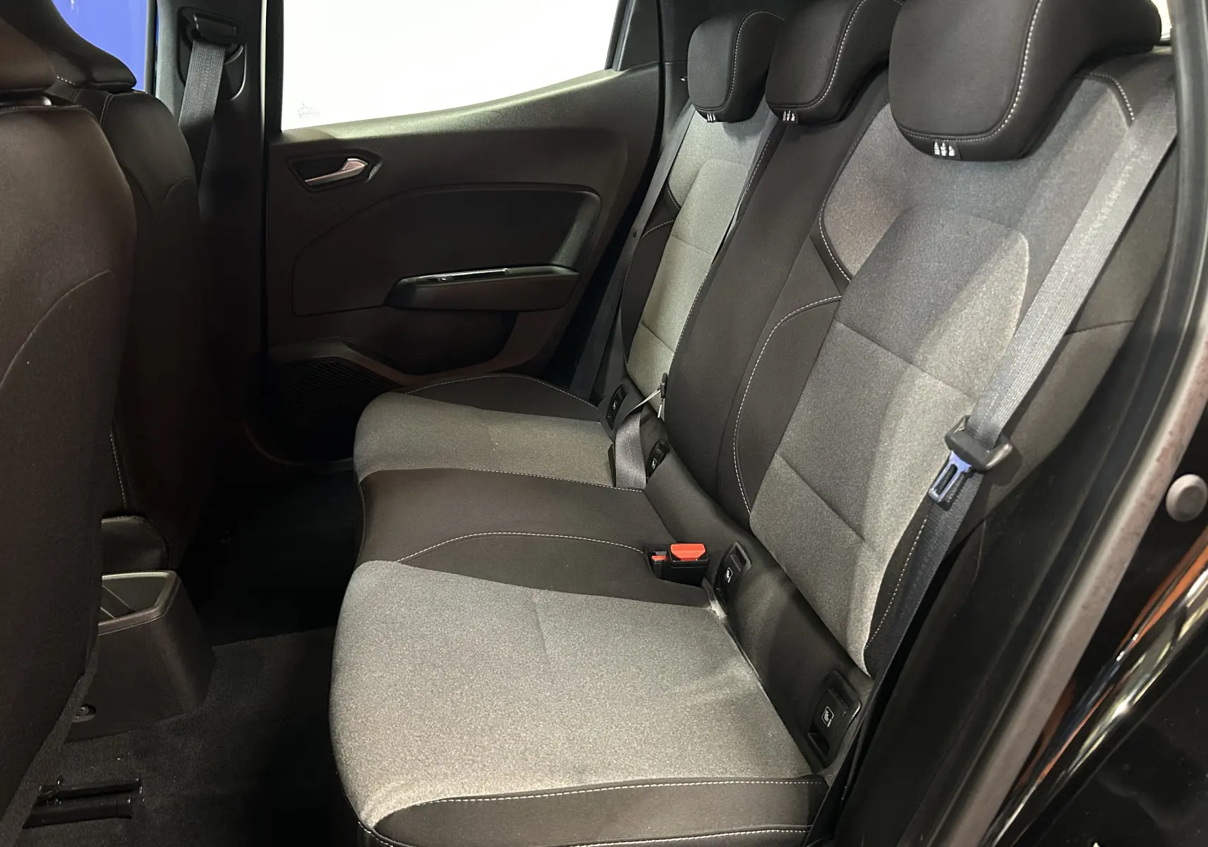 Vue intérieure côté droit des sièges arrière en tissu gris et noir de la Renault Clio V noire de 2025.