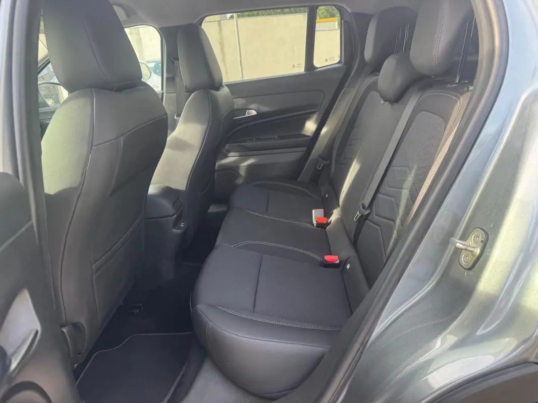 Vue intérieure côté droit montrant la banquette arrière noire du Jeep Avenger gris 2025 avec finitions tissu et cuir.