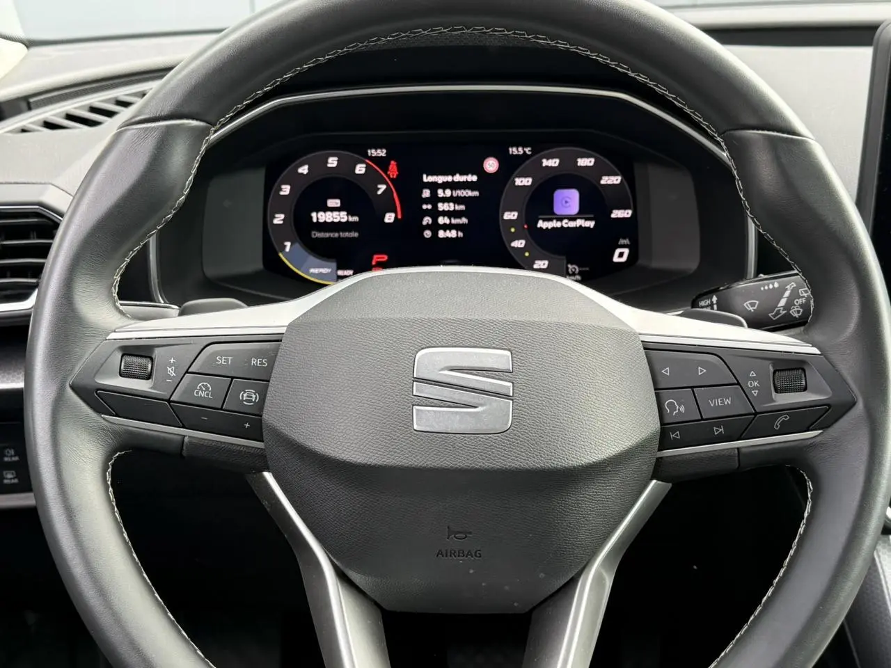 Vue rapprochée du volant cuir multifonction SEAT Leon 2025 avec tableau de bord digital affichant Apple CarPlay.