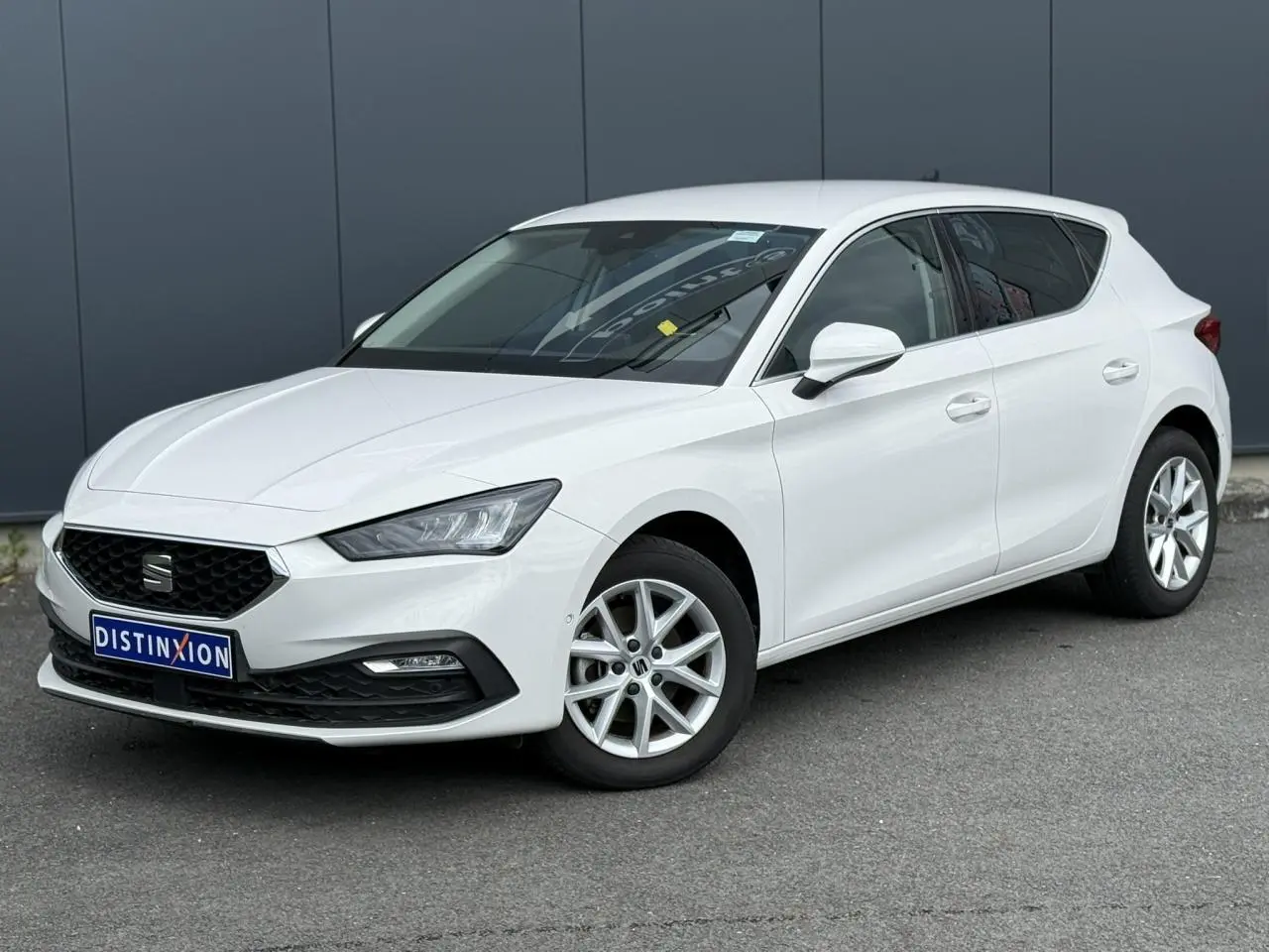 SEAT Leon blanc vue 3/4 avant droit, avec jantes alliage 16 pouces et calandre noire distinctive.