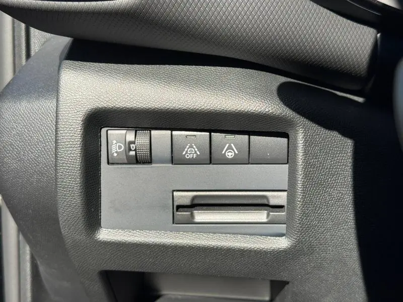 Gros plan sur les commandes de réglage des phares et aides à la conduite sur tableau de bord noir du Citroën C5 Aircross 2025.