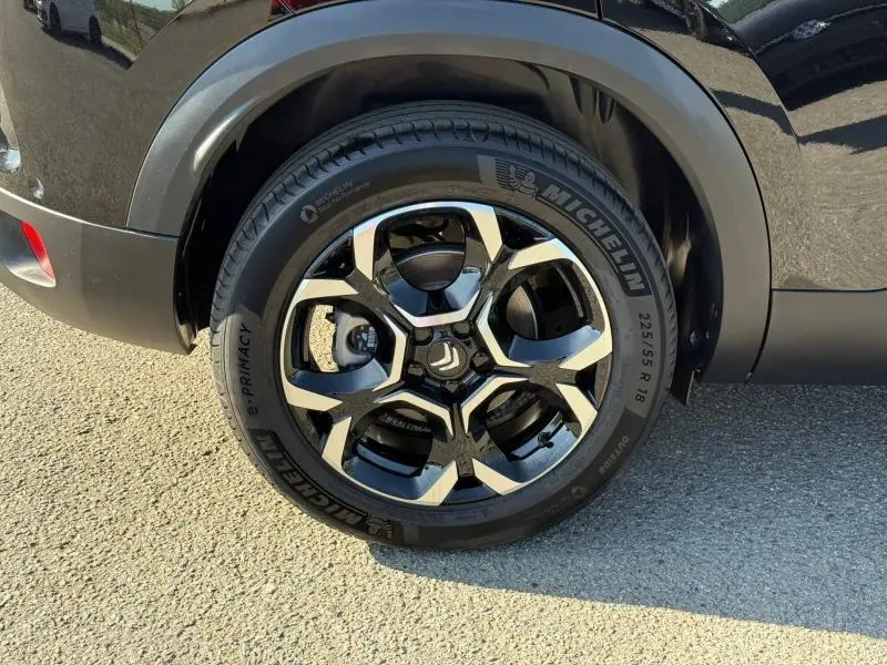 Gros plan sur la roue avant gauche du Citroën C5 Aircross noir Perla Nera avec jante alu bicolore et pneu Michelin.