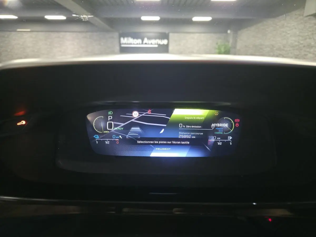 Affichage numérique du tableau de bord de la Peugeot 308 hybride rechargeable 2024, avec navigation et indicateurs de charge.