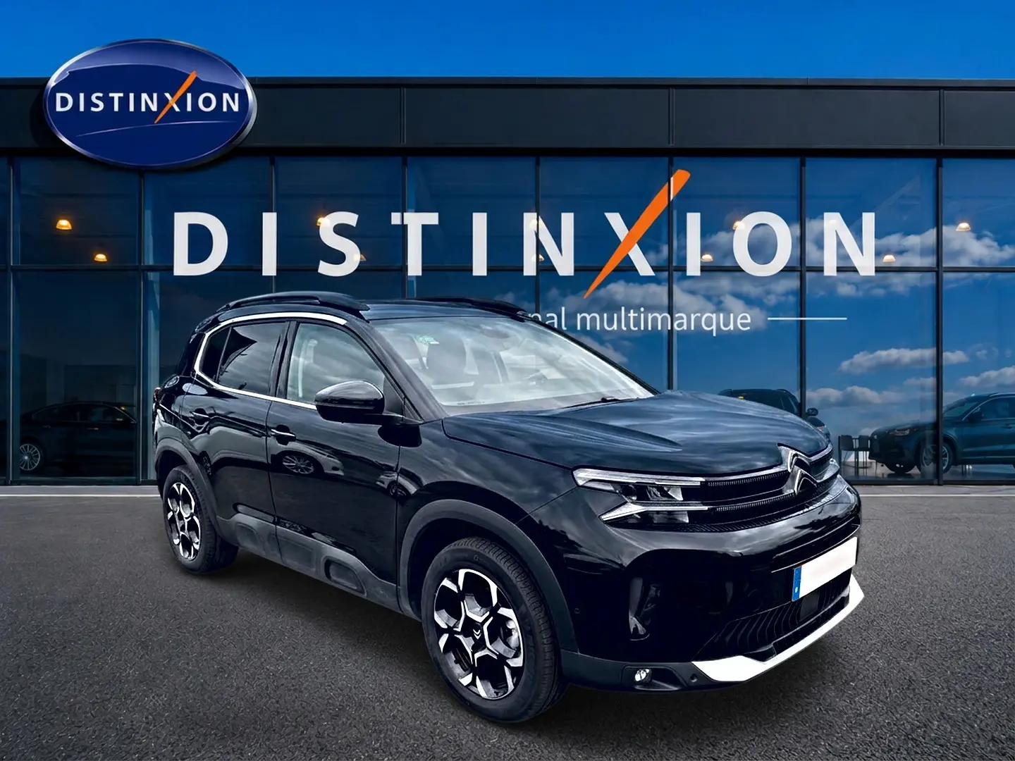 Citroën C5 Aircross noir vue 3/4 avant droit avec jantes alu et barres de toit devant vitrine Distinxion.